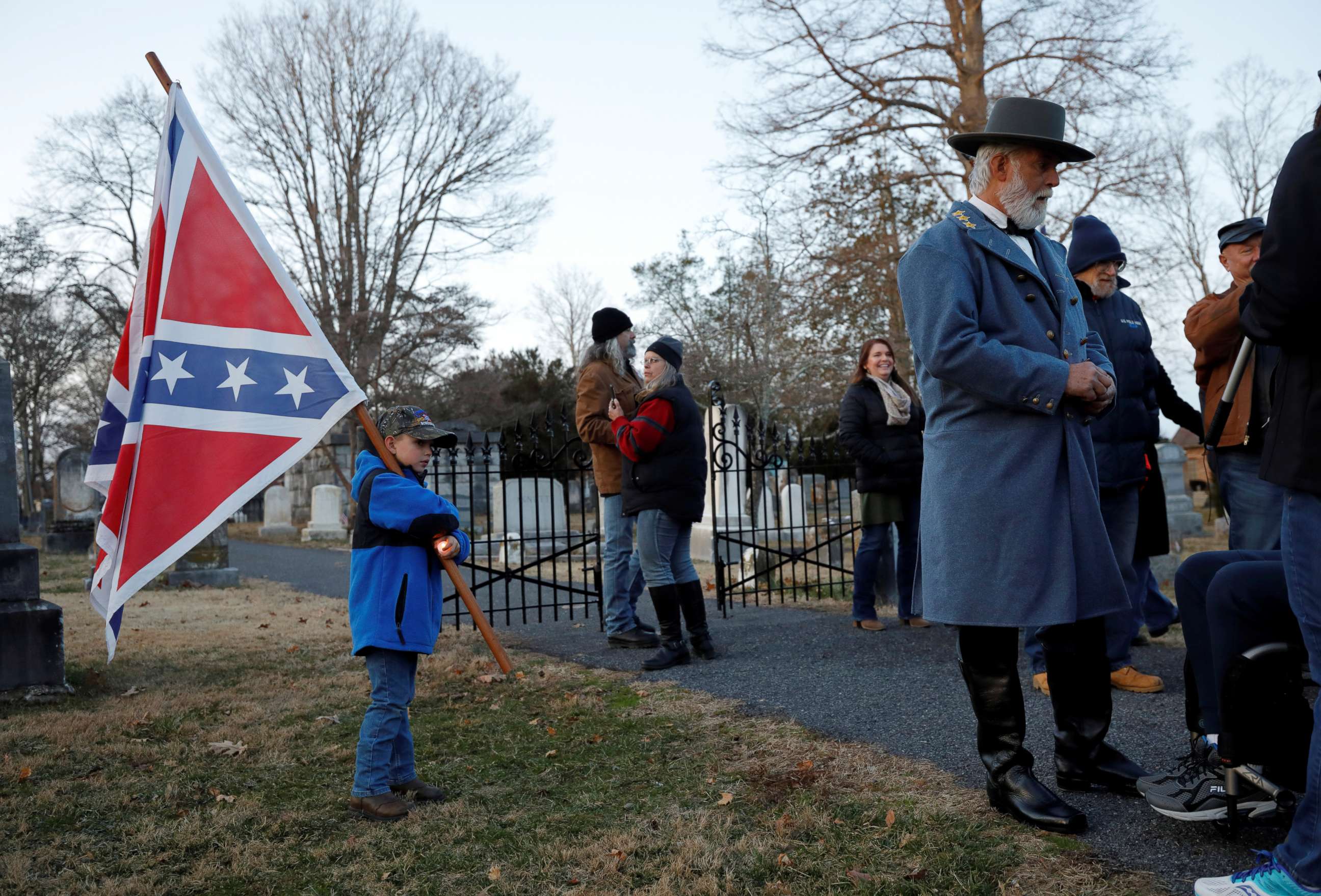 PHOTO: Supporters of Confederate statues and symbols, with a child carrying a Confederate flag and an impersonator of Confederate General Robert E. Lee, gather at the Jackson Memorial Cemetery on Lee-Jackson Day in Lexington, Va., Jan. 17, 2020. 