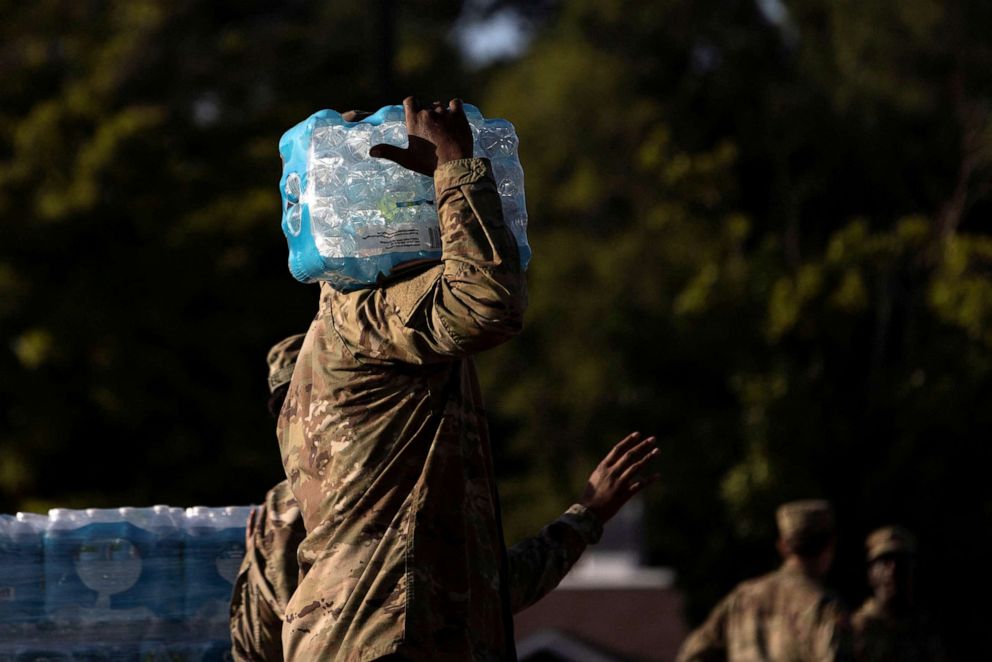 PHOTO: A member of the National Guard carries bottles of drinking water at a distribution site in Jackson, Mississippi, Sept. 1, 2022. 