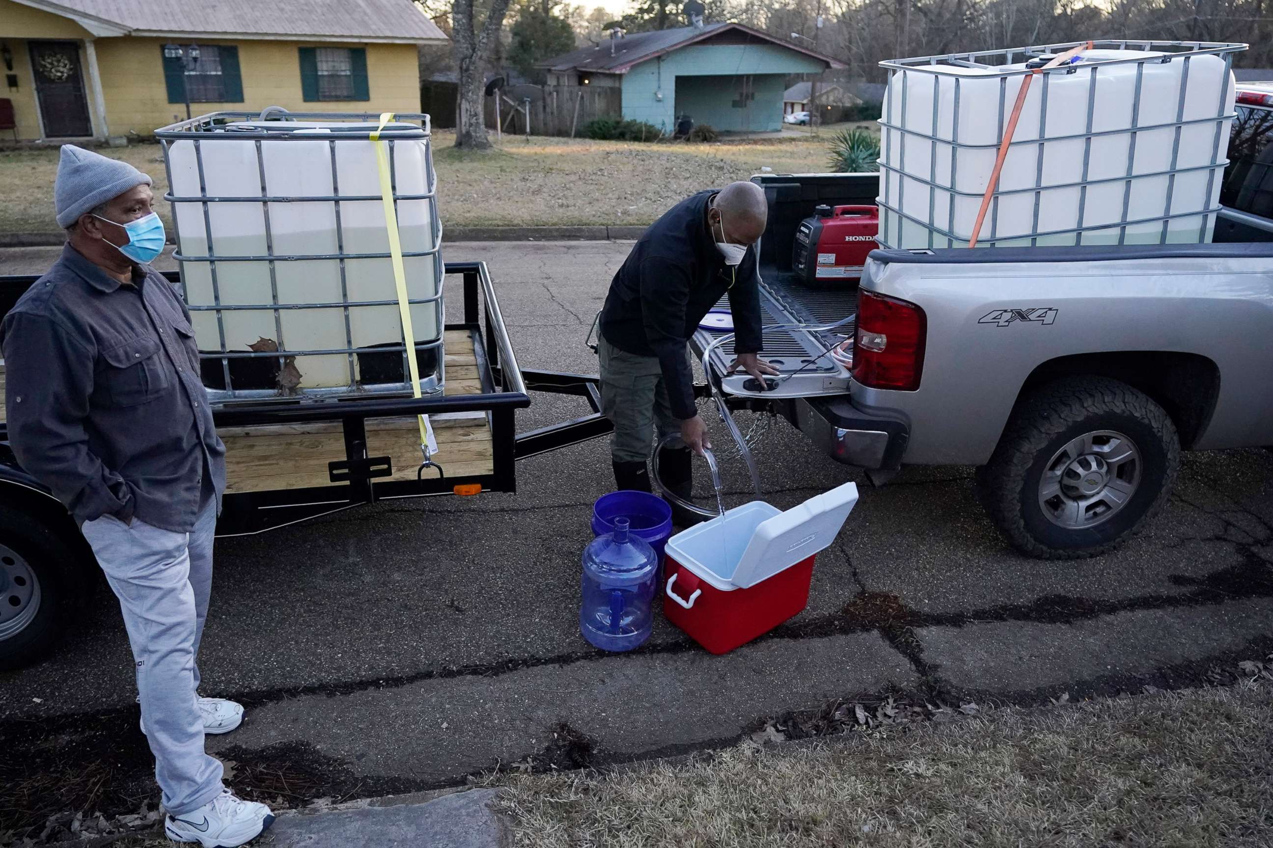 PHOTO: City of Jackson councilman and State Rep. De'Keither Stamps pours potable water into an ice chest and empty jugs for a resident in Jackson, Miss., Feb. 22, 2021.