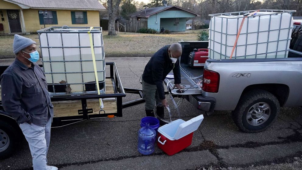 PHOTO: City of Jackson councilman and State Rep. De'Keither Stamps pours potable water into an ice chest and empty jugs for a resident in Jackson, Miss., Feb. 22, 2021.