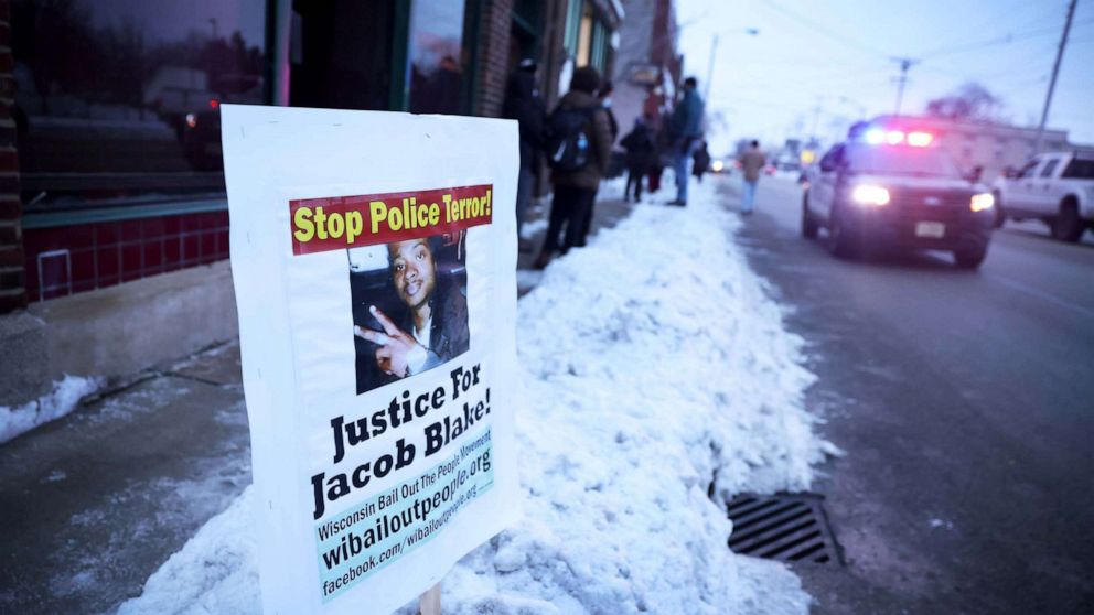 PHOTO: A police car drives past a sign showing support for Jacob Blake Jr. in Kenosha, Wisc., Jan. 04, 2021.