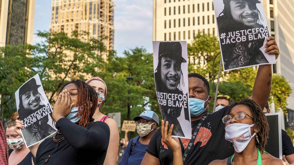 PHOTO: Protesters hold signs outside the Minneapolis 1st Police precinct during a demonstration against police brutality and racism on Aug. 24, 2020 in Minneapolis. 