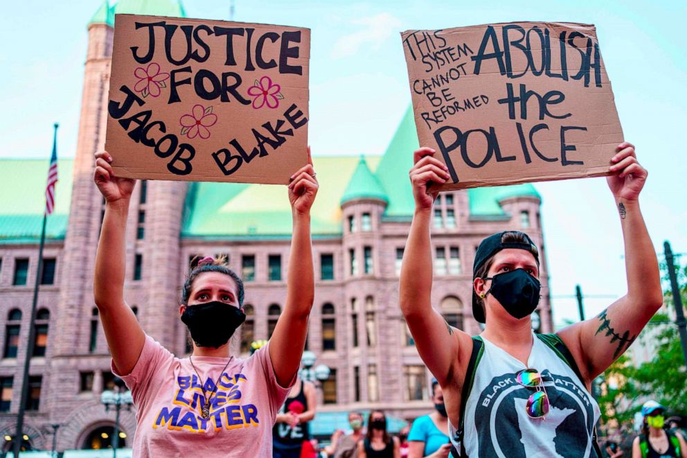 PHOTO: Protesters hold signs outside the Hennepin County Government Center in Minneapolis, Minnesota, on Aug. 24, 2020, during a demonstration against police brutality and racism.