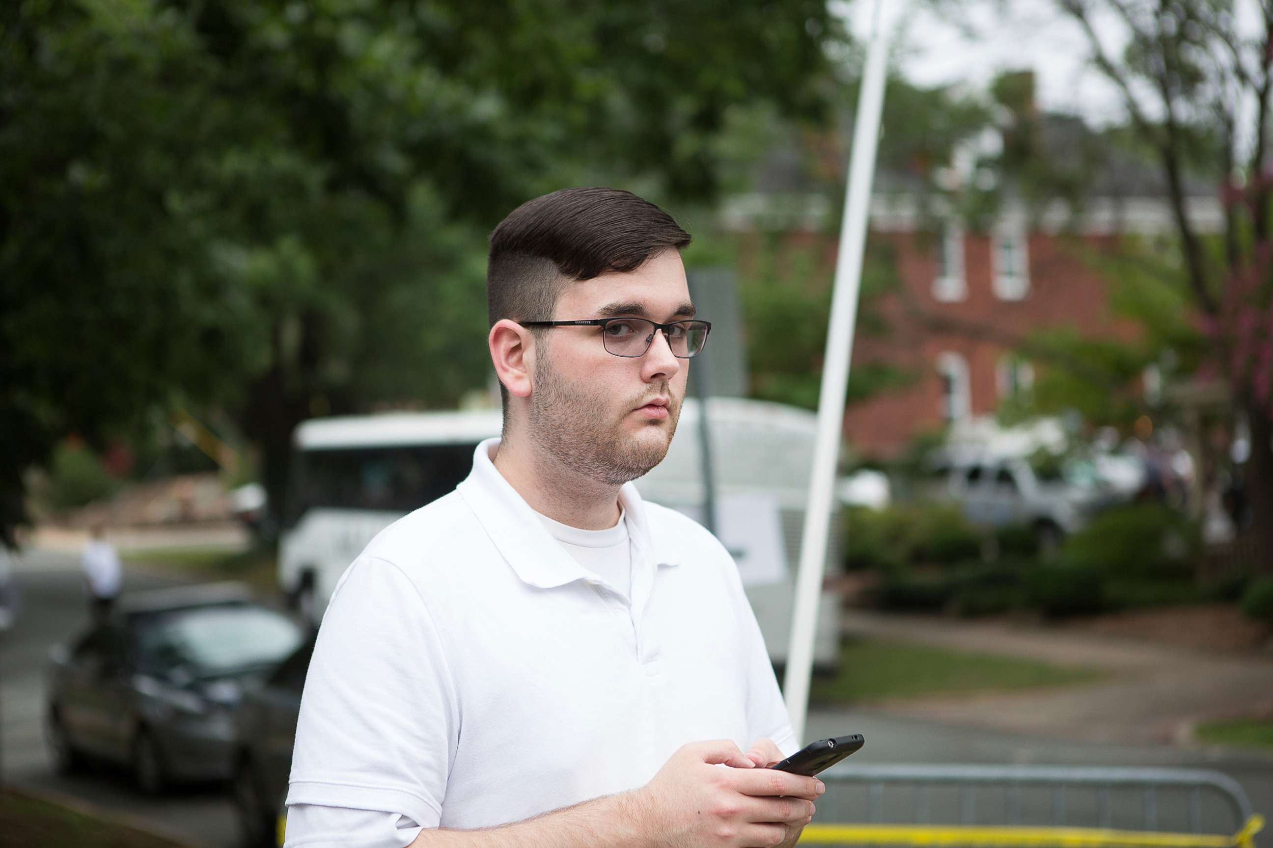 PHOTO: In this Saturday, Aug. 12, 2017, photo, James Alex Fields Jr. stands on the sidewalk looking at the procession of the clergy as they gathered at McGaffey park, ahead of a rally in Charlottesville, Va.