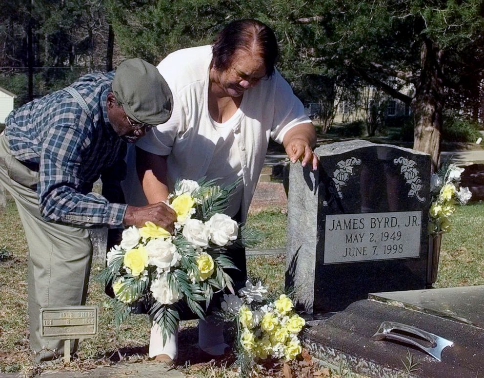 PHOTO: James Byrd Sr. and Stella arrange flowers around a new headstone commemorating their son, James Byrd Jr., Feb. 1, 1999, in Jasper, Texas.