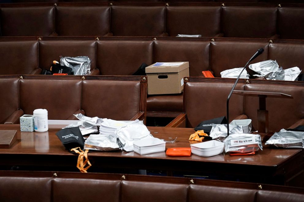 PHOTO: Papers and gas masks are left behind after House of Representatives members left the floor of the House chamber as rioters try to break into the chamber at the U.S. Capitol on Jan. 6, 2021, in Washington.