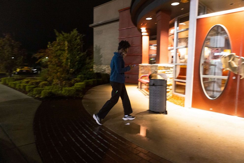 PHOTO: Jane Johnson runs into Red Robin to pick up food while working for the delivery app, DoorDash, Oct. 29, 2021, in Birmingham, Ala. 