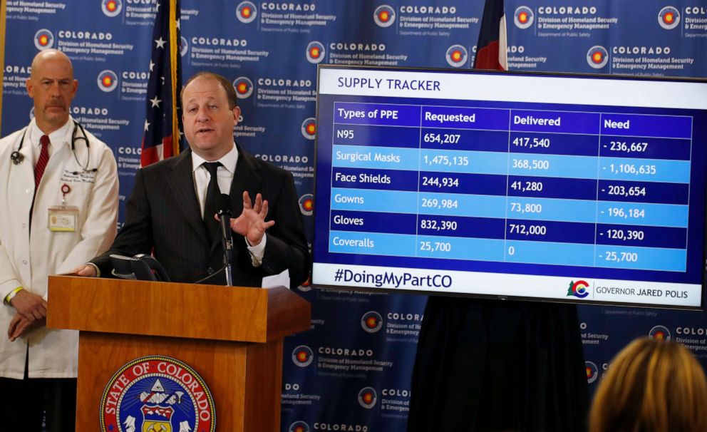 PHOTO: Colorado Gov. Jared Polis, front, makes a point as Dr. Marc Moss, a professor at the University of Colorado, looks on during a news conference on the spread of the new coronavirus Monday, March 30, 2020, in Centennial, Colo.