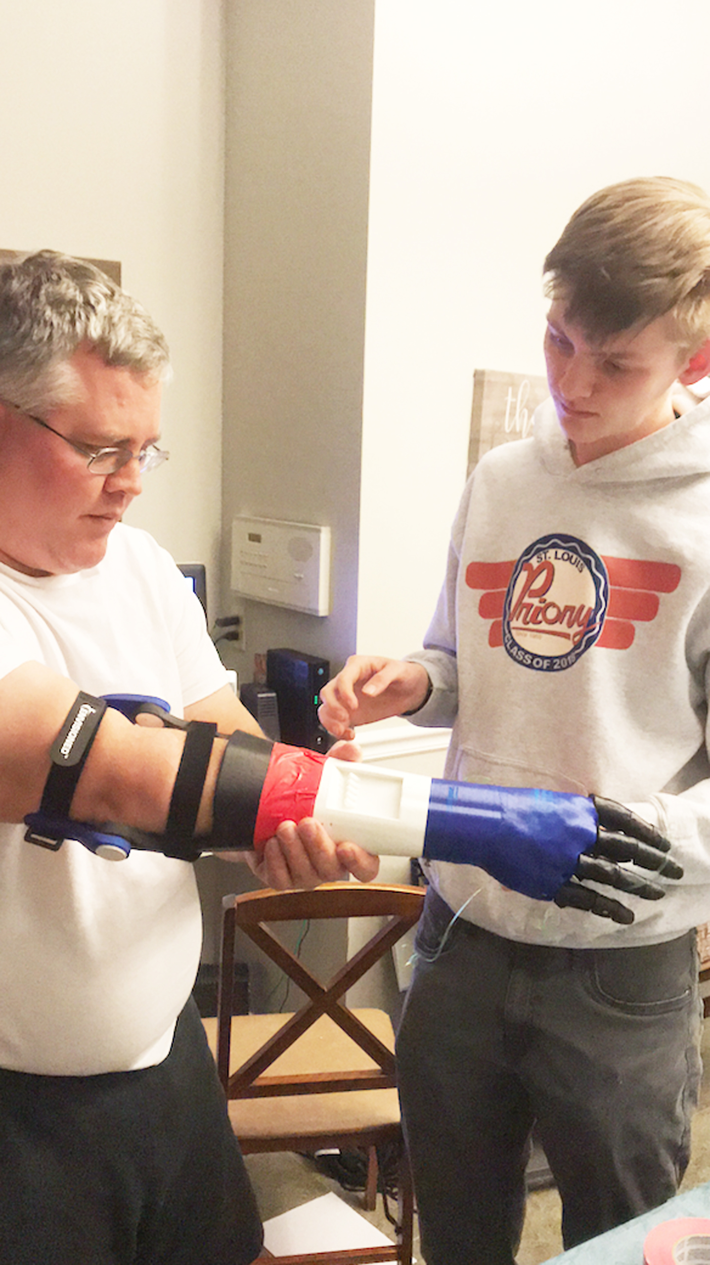 PHOTO: Jason Frei tries on a prosthetic arm made for him by son Robbie Frei, a senior.