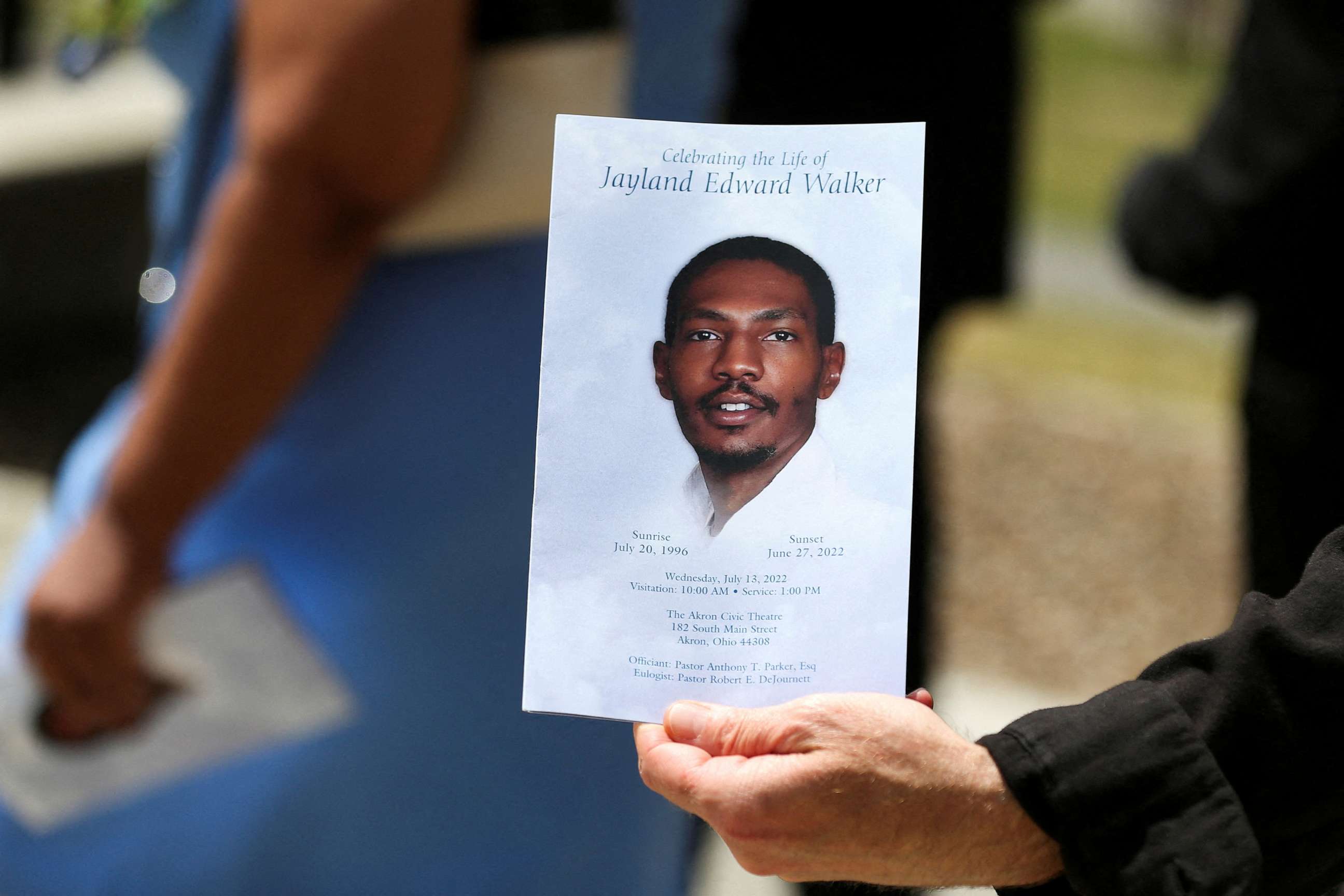 PHOTO: In this July 13, 2022, file photo, a man holds up the program following the funeral services for Jayland Walker, a 25 year old black man was shot to death by up to eight police officers on June 27, 2022, in Akron, Ohio.