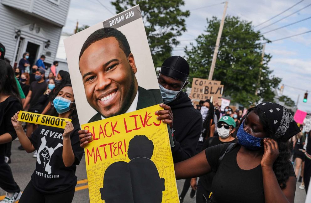 PHOTO: A demonstrator holds a sign for Botham Jean while marching during a demonstration, June 9, 2020, in Revere, Mass., for George Floyd and other Black Americans killed at the hands of law enforcement. 