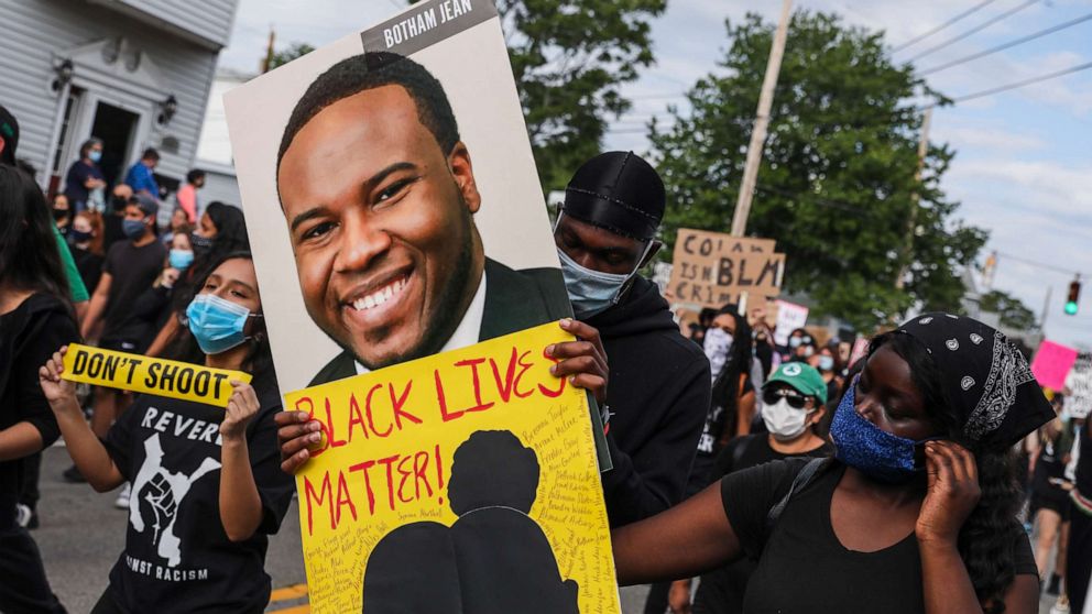 PHOTO: A demonstrator holds a sign for Botham Jean while marching during a demonstration, June 9, 2020, in Revere, Mass., for George Floyd and other Black Americans killed at the hands of law enforcement. 