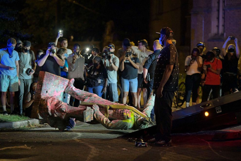 PHOTO: A crowd gathers at the statue of Confederate President Jefferson Davis after it was pulled down off of its pedestal on Monument Avenue in Richmond, VA., on June 10, 2020.