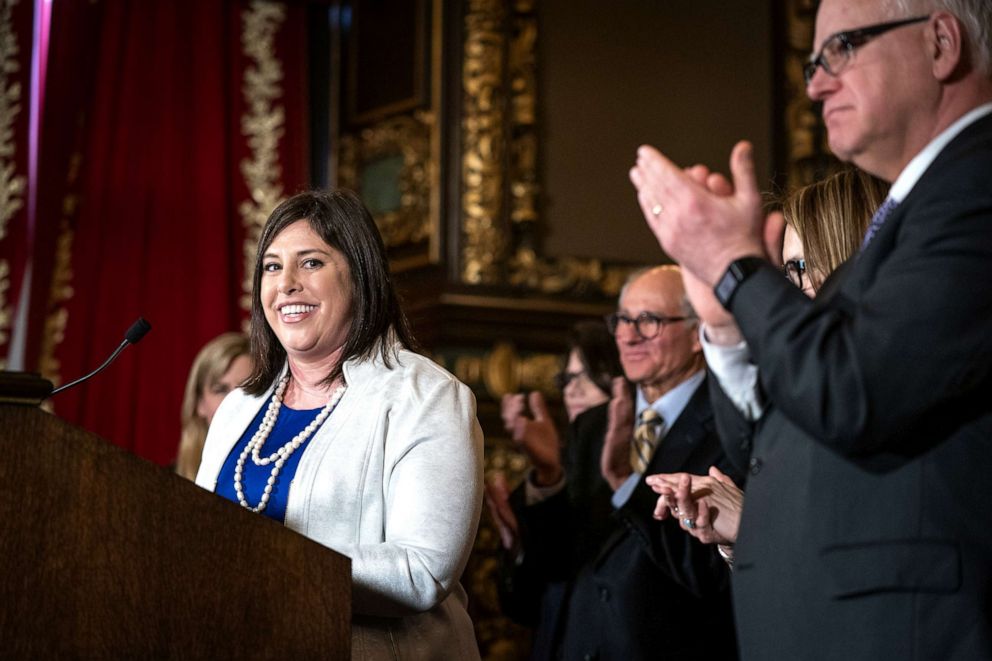 PHOTO: Jenny Teeson receives applause while speaking after Gov. Tim Walz signed into law a repeal of the state's pre-existing relationship defense at the Capitol in St. Paul on Thursday, May 2, 2019.