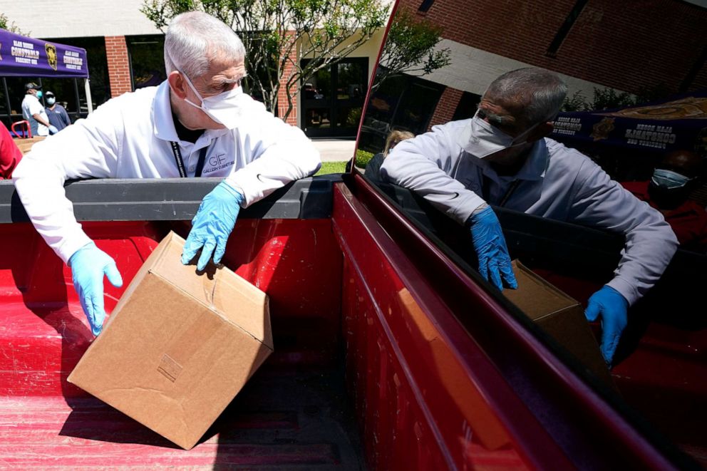 PHOTO: Houston businessman and philanthropist Jim McIngvale loads a box of food into the back of a pickup truck at a distribution site, April 14, 2020, in Houston.