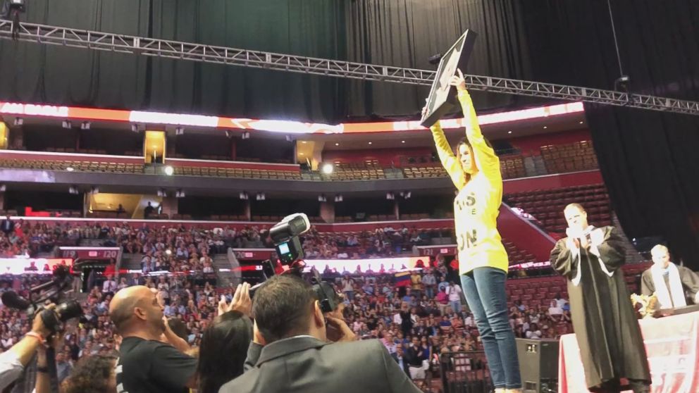 PHOTO: The parents of Joaquin Oliver, one of the students slain in the deadly shooting at Marjory Stoneman Douglas in February, walk on stage during graduation to accept his diploma.