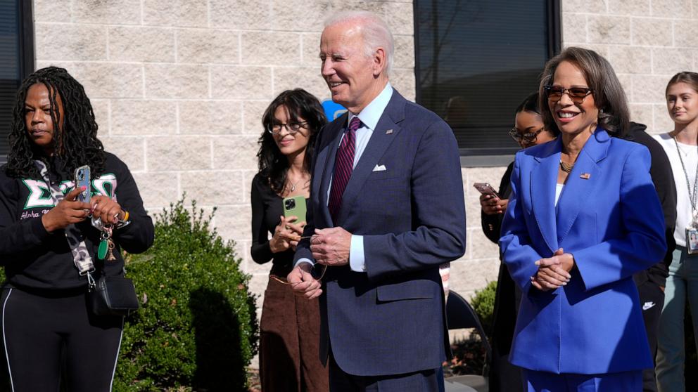 PHOTO: President Joe Biden, center, and Rep. Lisa Blunt Rochester wait in line before voting at an early-voting polling station, Oct. 28, 2024, in New Castle, Del.