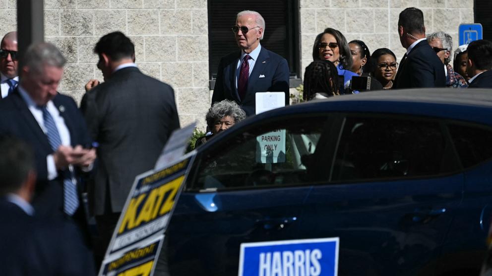 PHOTO: President Joe Biden, center, and Rep. Lisa Blunt Rochester wait in line before voting at an early-voting polling station, Oct. 28, 2024, in New Castle, Del.