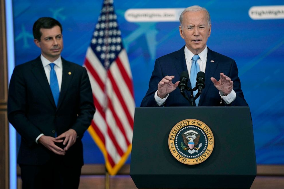 PHOTO: Transportation Secretary Pete Buttigieg listens as President Joe Biden delivers remarks on requiring airlines to compensate passengers for extensive flight delays and cancellations in the South Court Auditorium on the White House complex.