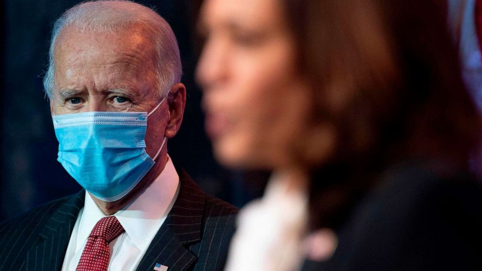 PHOTO: President-elect Joe Biden looks on as Vice president-elect Kamala Harris delivers remarks following a meeting with the Governors and Covid team on Nov. 19, 2020 in Wilmington, Del.