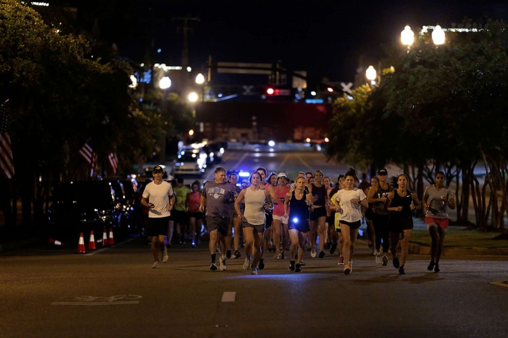 PHOTO: Runners make their way down Main Street in Tupelo, Miss. as they hold their "Liza's Lights" run early Friday morning, Spet. 9, 2022, in Tupelo Miss.