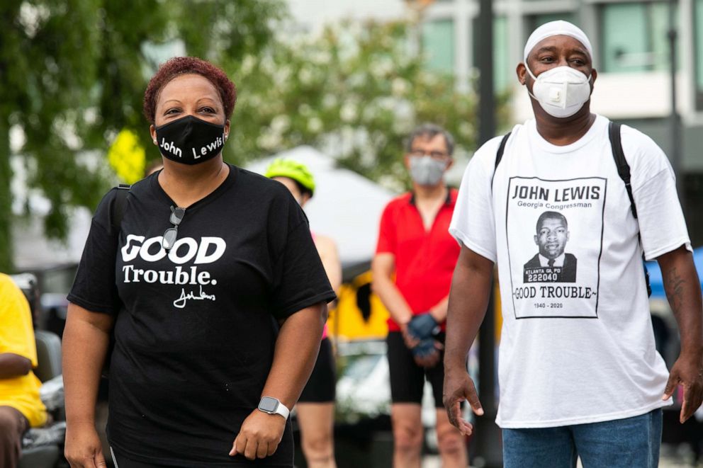 PHOTO: Pam Hooks, left, and Eddie Smith watch the funeral procession for civil rights icon Rep. John Lewis as his casket arrives at Ebenezer Baptist Church on July 30, 2020, in Atlanta.