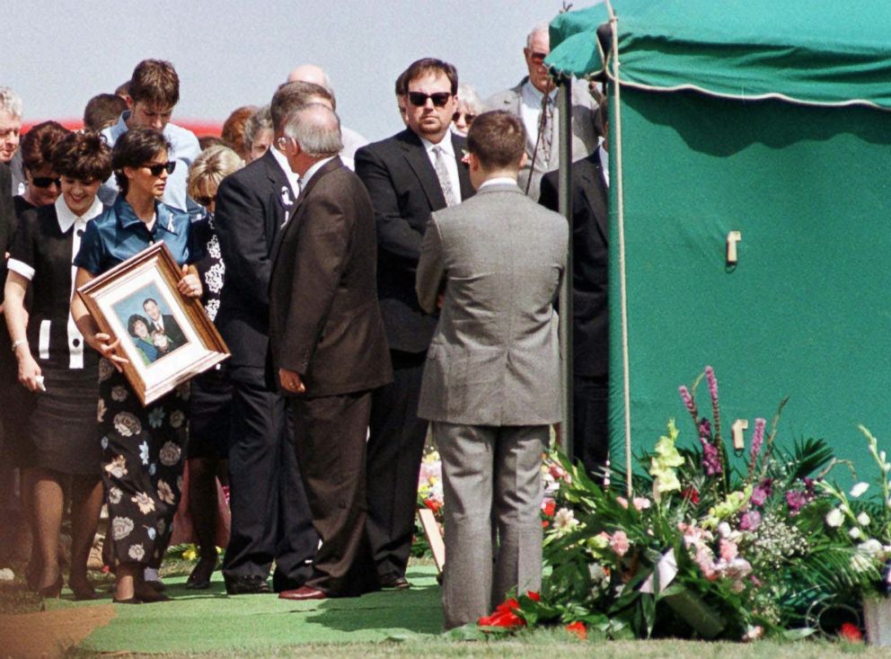 PHOTO: A mourner carries the Wright family portrait to the gravesite of slain Westside Middle School teacher Shannon Wright before burial services, March 28, 1998, in Jonesboro, Ark.