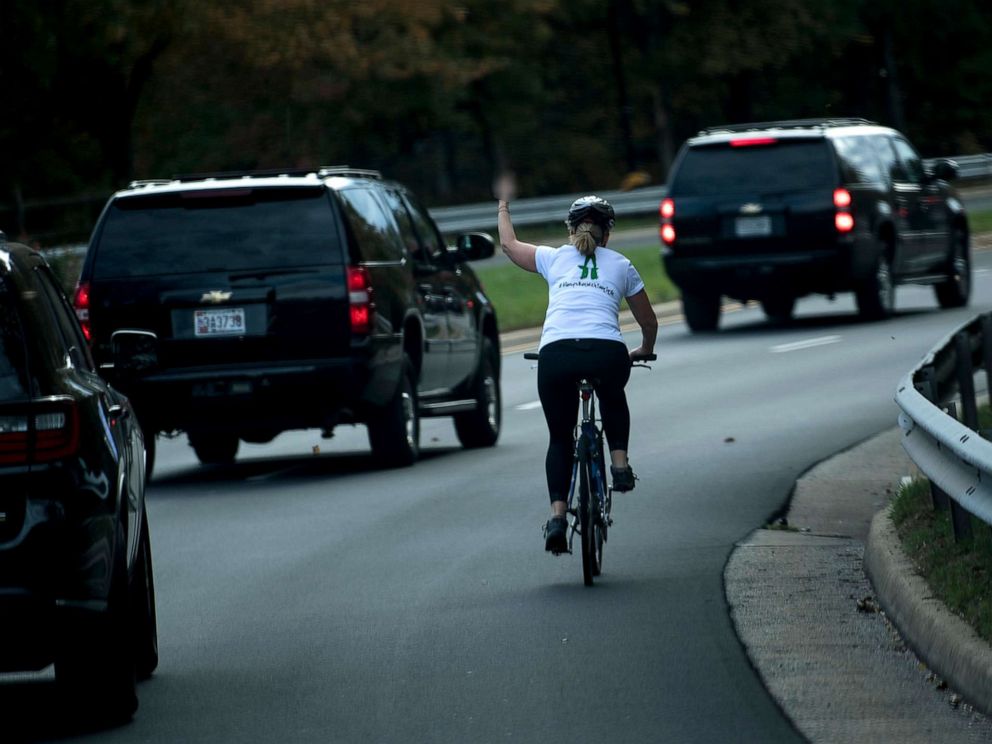 PHOTO: Juli Briskman gestures with her middle finger as a motorcade with President Donald Trump departs Trump National Golf Course on Oct. 28, 2017, in Sterling, Va.