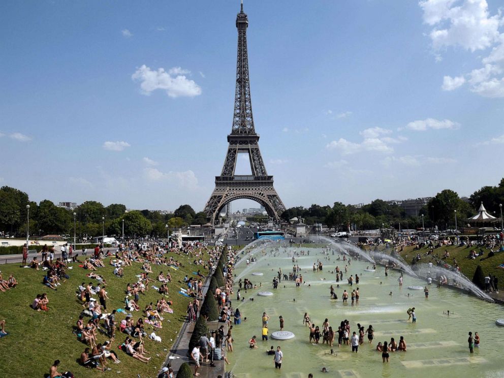 PHOTO: In this file photo taken on July 25, 2019, people cool off and sunbathe by the Trocadero Fountains next to the Eiffel Tower in Paris, as a new heatwave hits the French capital.