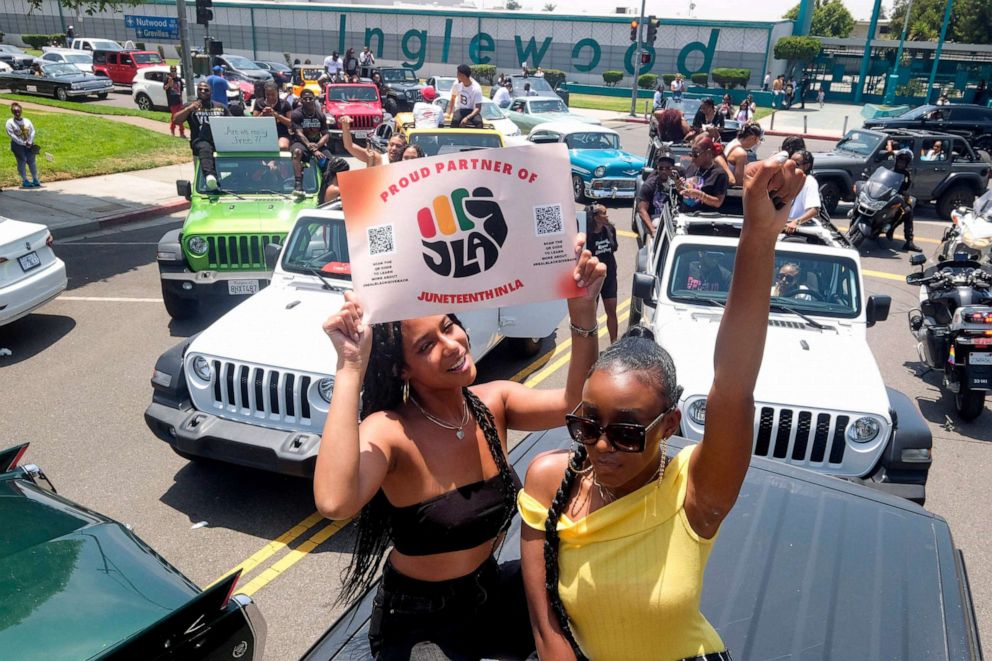 PHOTO: FILE - Jasmine Kingi, left, 26, and Robin Renee Green, 26, both from Los Angeles, celebrate as they take part in a car parade to mark Juneteenth in Inglewood, Calif, June 19, 2021.