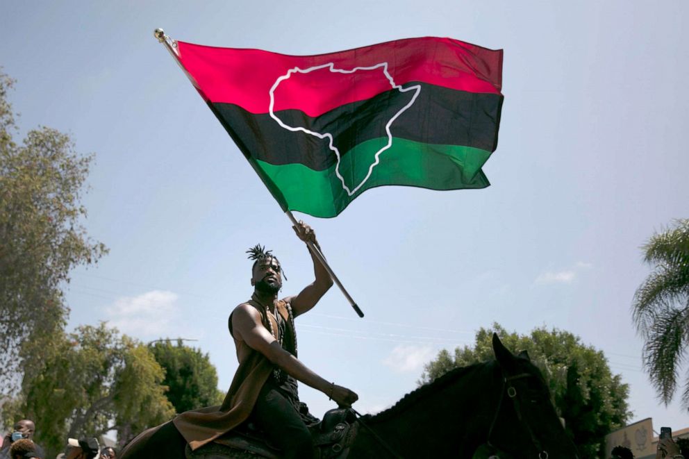 PHOTO: Rein Morton waves a Pan-African flag on horseback during a Juneteenth celebration in Los Angeles, June 19, 2020.