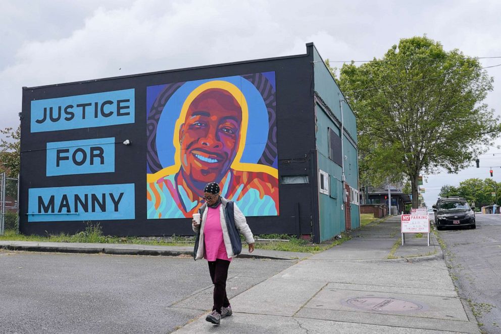 PHOTO: A woman walks past a mural honoring Manuel "Manny" Ellis in the Hilltop neighborhood of Tacoma, Washington, on May 27, 2021. Ellis died after he was restrained by police officers on March 3, 2020.