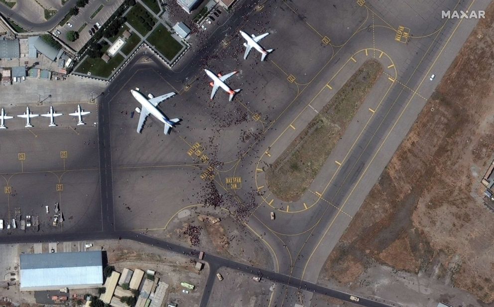 PHOTO: Crowds of people flood the tarmac at the Hamid Karzai International Airport in Kabul, Afghanistan, Aug. 16, 2021.