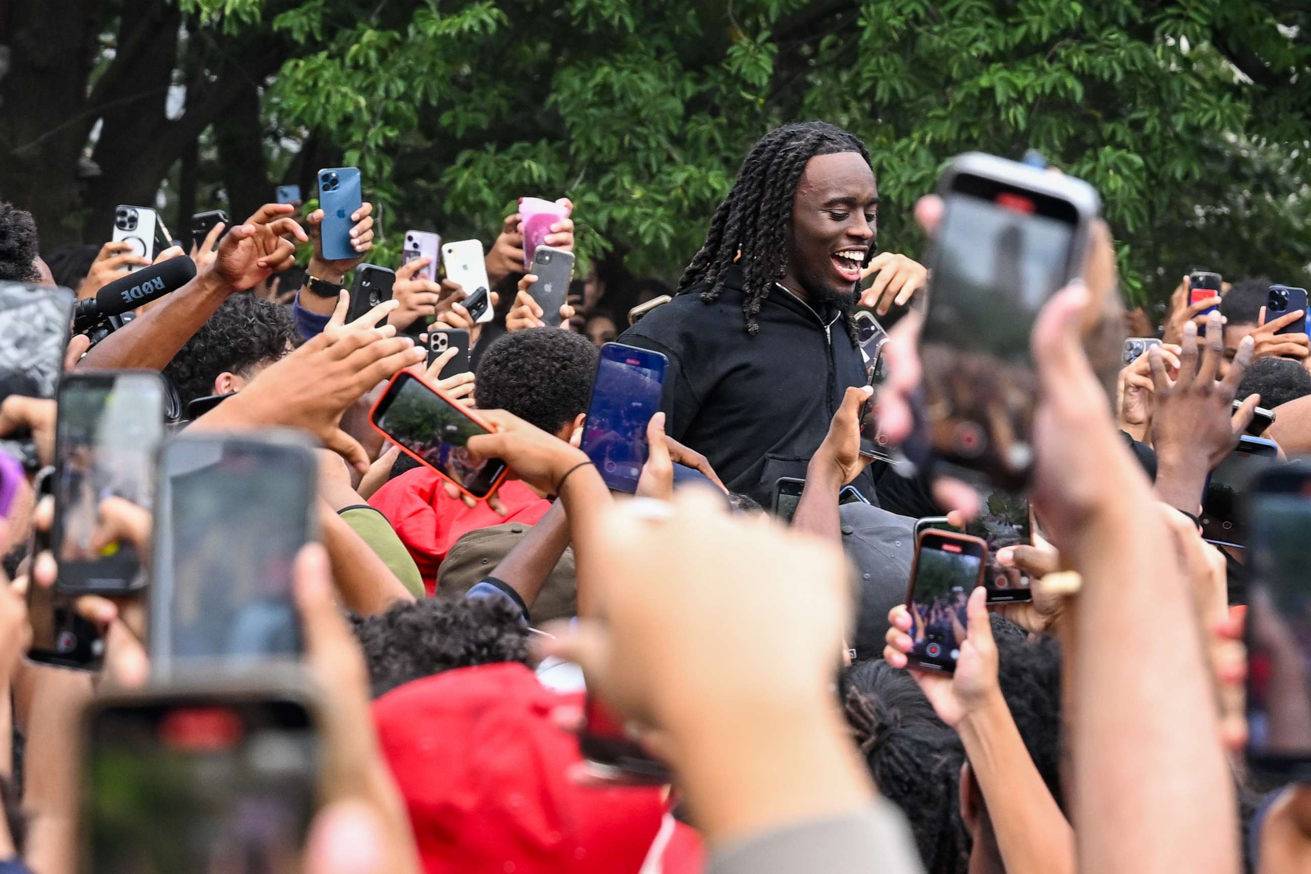 PHOTO: People gather around and cheer for Kai Cenat, center, as members of the NYPD respond to thousands of people gathered for a "giveaway" event in Union Square and the surrounding area on Aug. 4, 2023, in New York City.