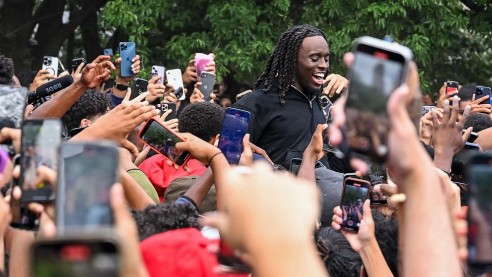 PHOTO: People gather around and cheer for Kai Cenat, center, as members of the NYPD respond to thousands of people gathered for a "giveaway" event in Union Square and the surrounding area on Aug. 4, 2023, in New York City.