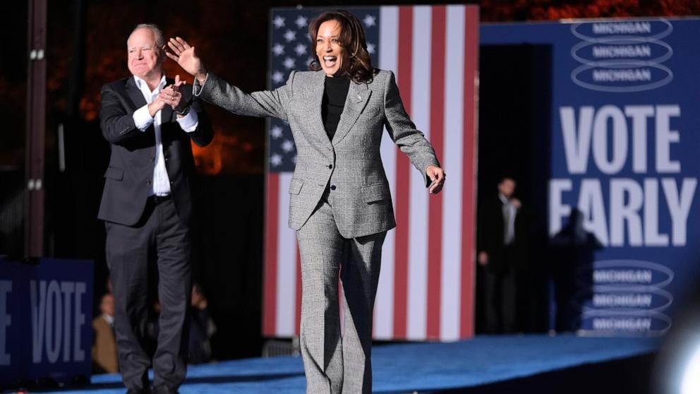 PHOTO: Democratic presidential nominee Vice President Kamala Harris, right, is greeted by her running mate Minnesota Gov. Tim Walz, as she arrives to speak at a campaign event in Burns Park, Oct. 28, 2024, in Ann Arbor, Mich.