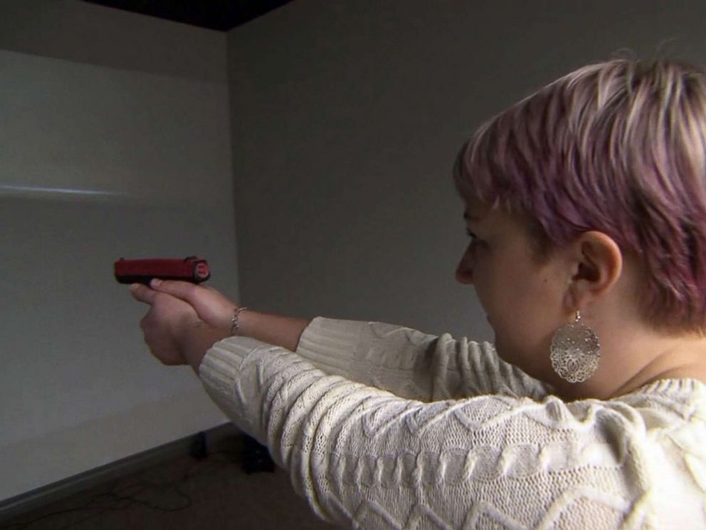 PHOTO: Kasey Hansen, a special education teacher in Utah, is seen here practicing at a gun range with a video simulation.