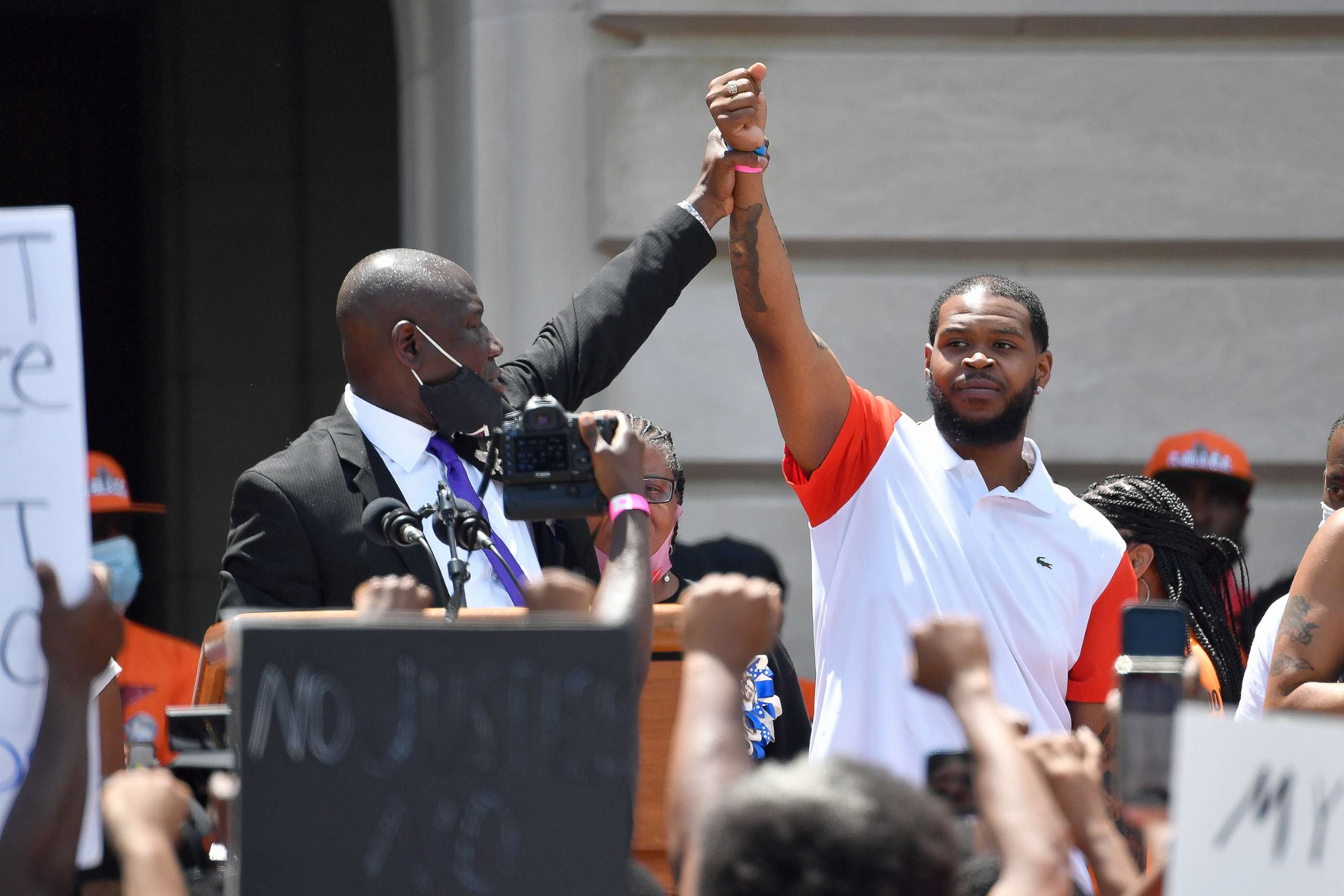 PHOTO: Attorney Benjamin Crump, left, holds up the hand of Kenneth Walker during a rally on the steps of the Kentucky State Capitol in Frankfort, Ky., June 25, 2020.