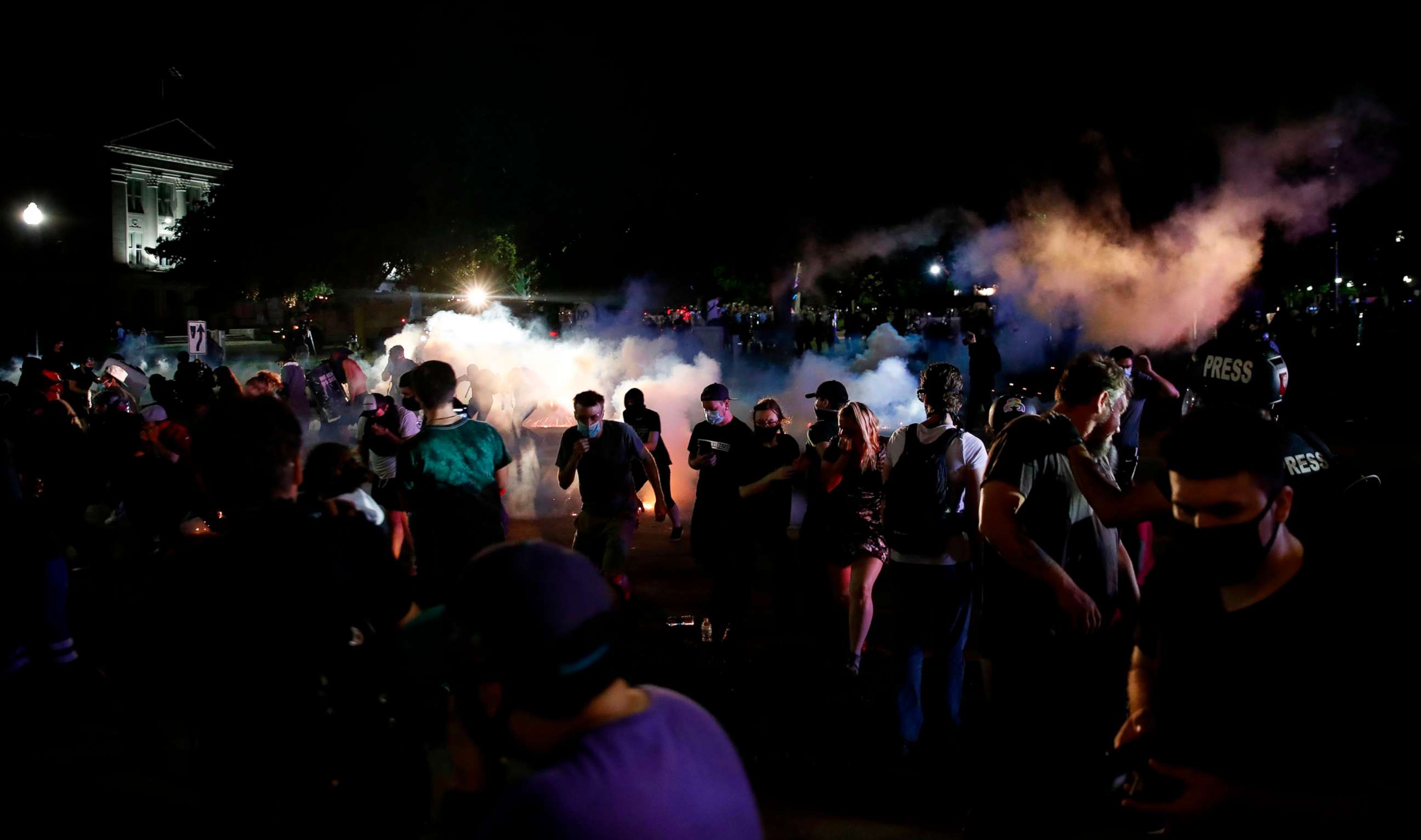 PHOTO: Protestors run for cover as police shoots teargas in an effort to disperse the crowd outside the County Courthouse during demonstrations against the shooting of Jacob Blake in Kenosha, Wis. on Aug. 25, 2020.