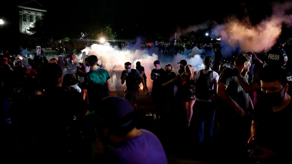 PHOTO: Protestors run for cover as police shoots teargas in an effort to disperse the crowd outside the County Courthouse during demonstrations against the shooting of Jacob Blake in Kenosha, Wis. on Aug. 25, 2020.
