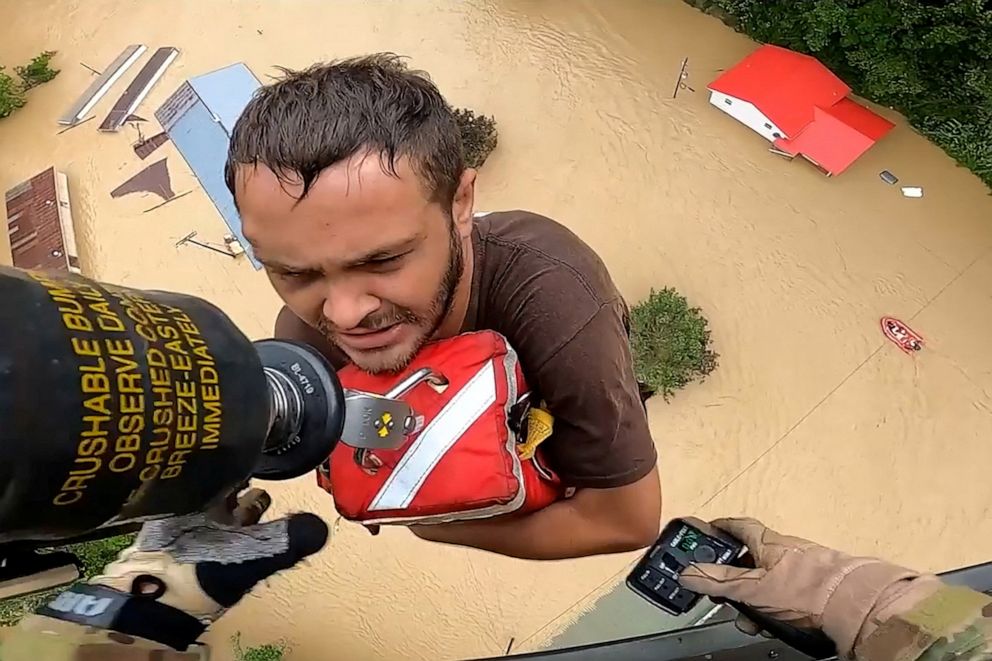 PHOTO: A man is rescued from flooding by the crew of a U.S. Army National Guard Blackhawk helicopter in eastern Kentucky, in a still image from video on July 28-29, 2022.
