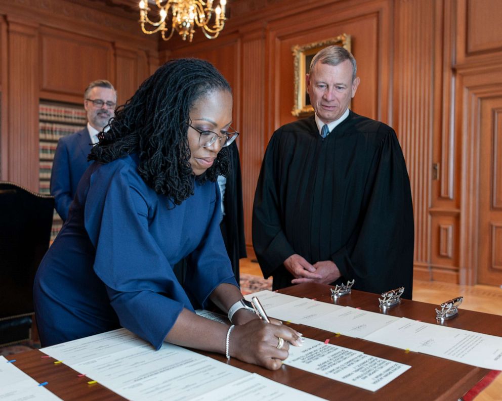 PHOTO: Chief Justice John G. Roberts, Jr., looks on as Justice Ketanji Brown Jackson signs the Oaths of Office in the Justices' Conference Room, in the Supreme Court Building in Washington, D.C., June 30, 2022.