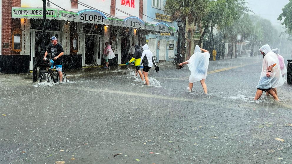 PHOTO: In this July 6, 2021, file photo, determined visitors head for Sloppy Joe's Bar while crossing a flooded Duval Street as heavy winds and rain pass over Key West, Fla., as Tropical Storm Elsa began lashing the Florida Keys.