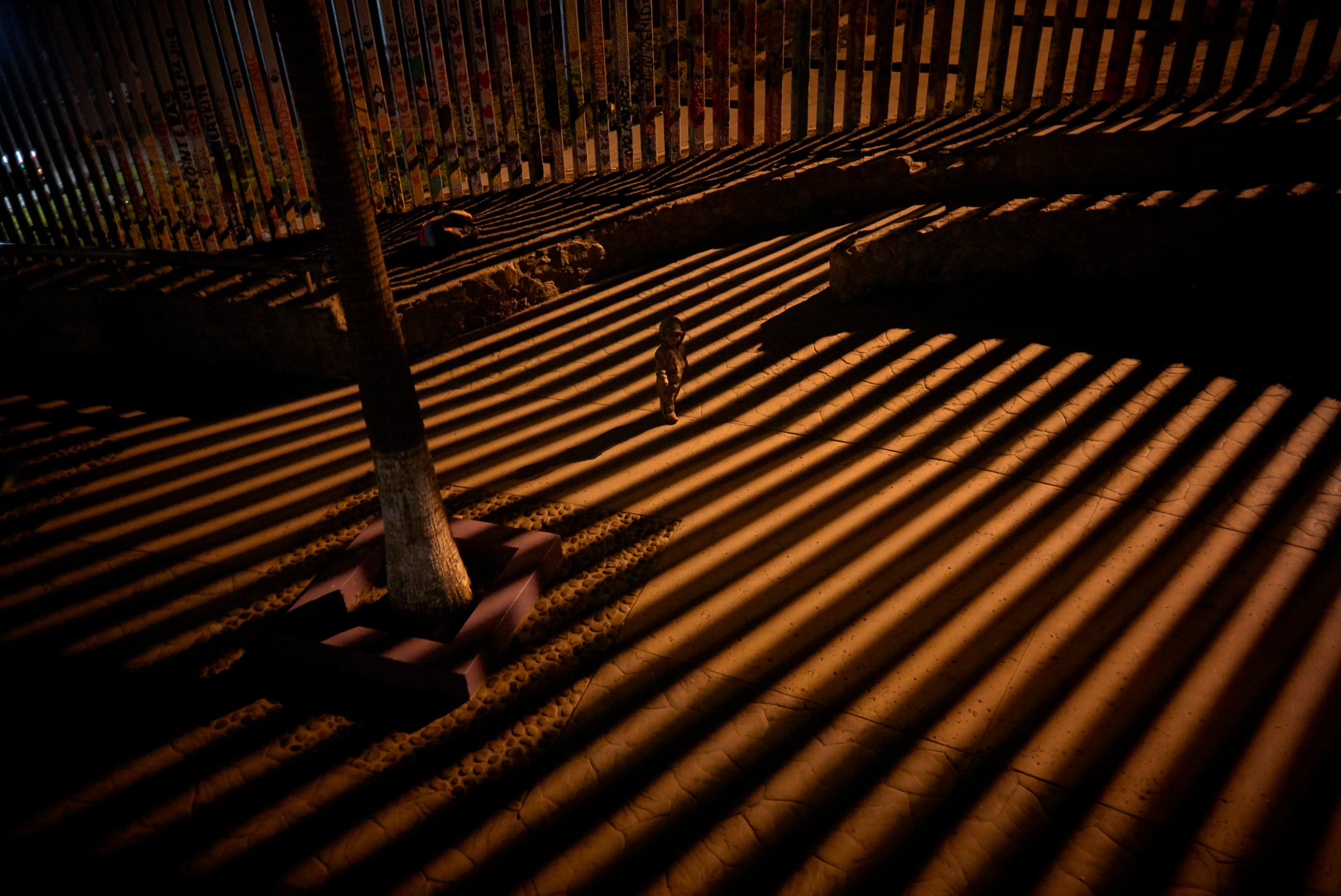 PHOTO: In this Jan. 11, 2019 photo, a boy plays as floodlights from the United States filter through the border wall in Tijuana, Mexico.