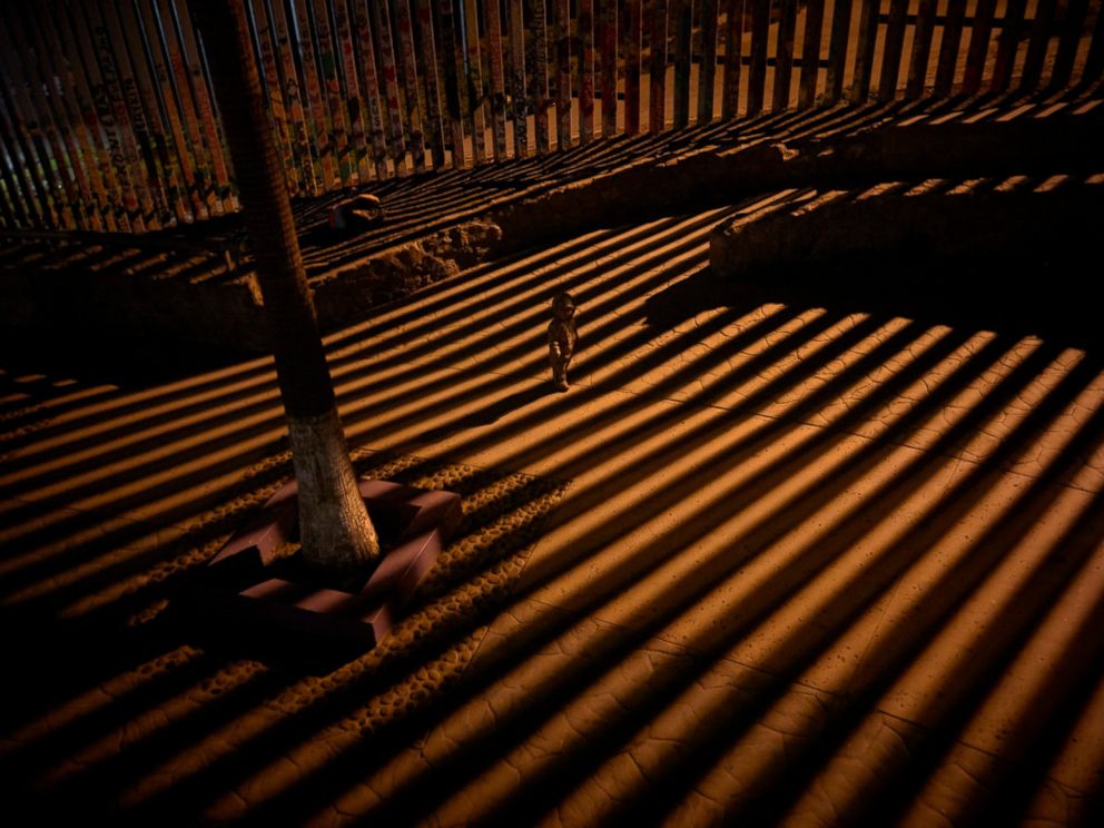 PHOTO: In this Jan. 11, 2019 photo, a boy plays as floodlights from the United States filter through the border wall in Tijuana, Mexico.