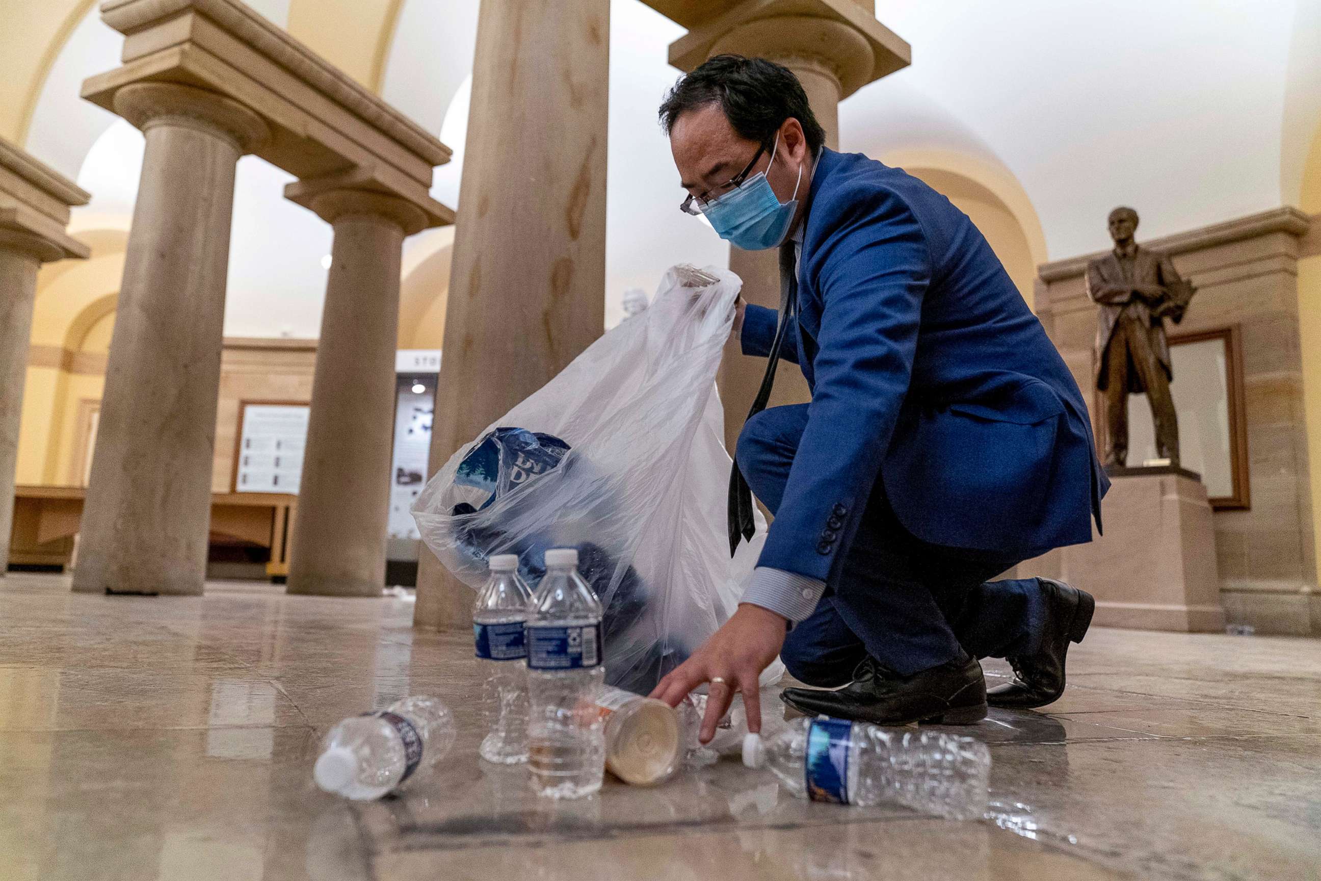 PHOTO: Rep. Andy Kim, Democrat from New Jersey, cleans up debris and trash strewn across the floor in the early morning hours, Jan. 7, 2021, after protesters stormed the Capitol in Washington, D.C., the day before.