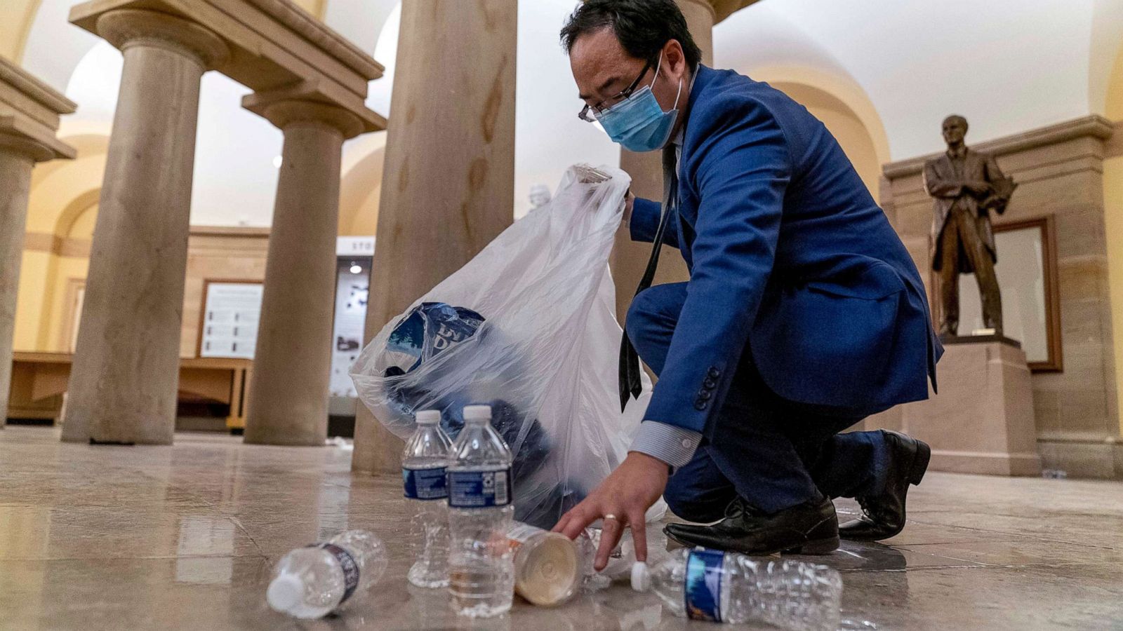 PHOTO: Rep. Andy Kim, Democrat from New Jersey, cleans up debris and trash strewn across the floor in the early morning hours, Jan. 7, 2021, after protesters stormed the Capitol in Washington, D.C., the day before.