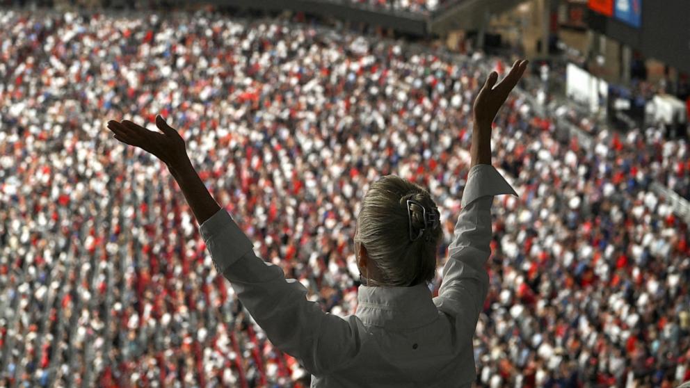 PHOTO: A person raises their arms during a memorial service for slain conservative commentator Charlie Kirk in Glendale, Arizona, September 21, 2025.