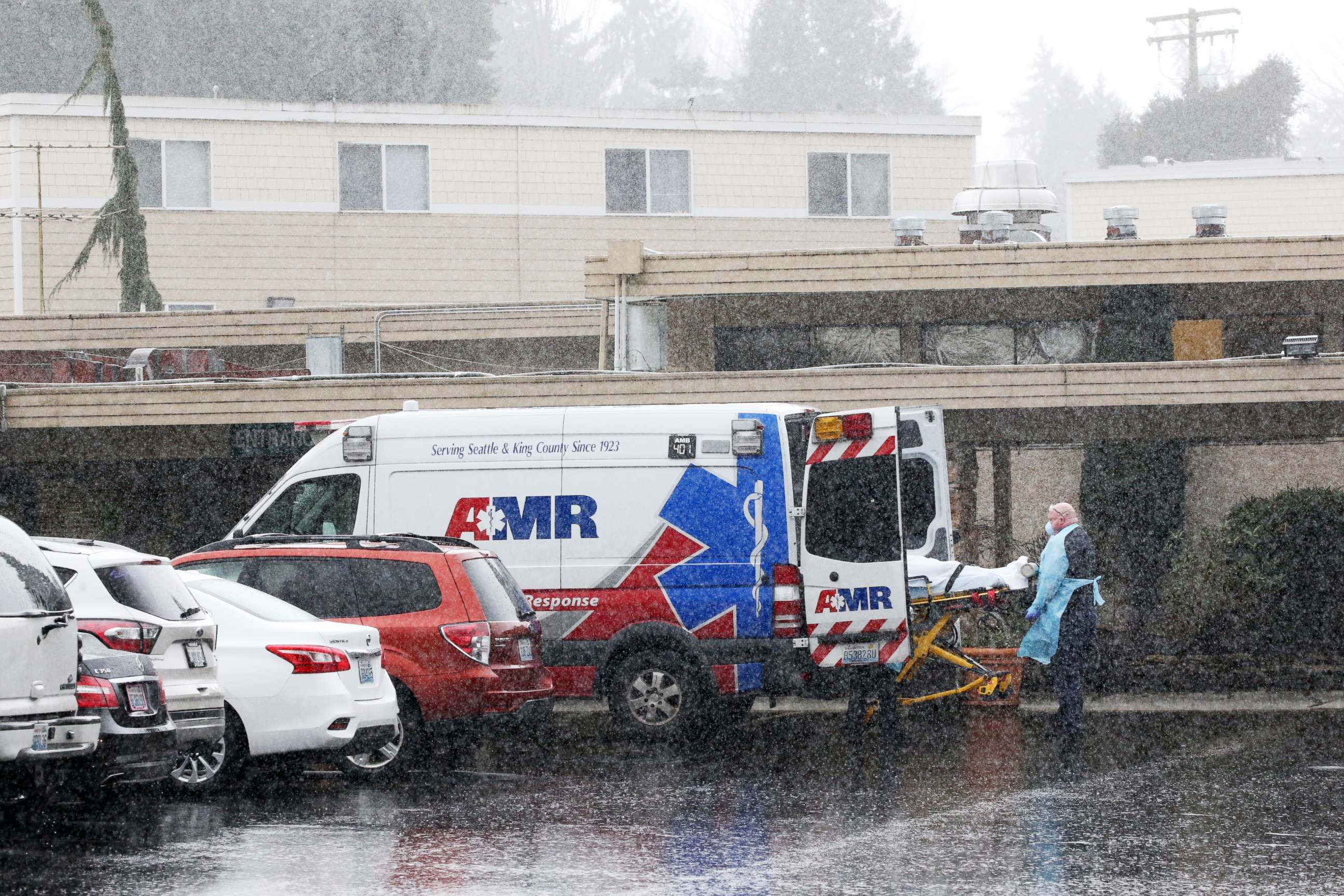 PHOTO: A patient is put into an ambulance during the pouring rain outside the Life Care Center of Kirkland in Kirkland, Wash., March 7, 2020.