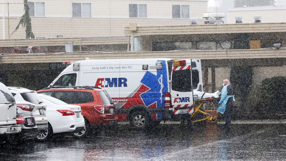 PHOTO: A patient is put into an ambulance during the pouring rain outside the Life Care Center of Kirkland in Kirkland, Wash., March 7, 2020.